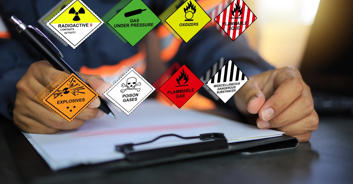 Someone is writing on a clipboard. Images of solvent hazard classifications float above the clipboard.