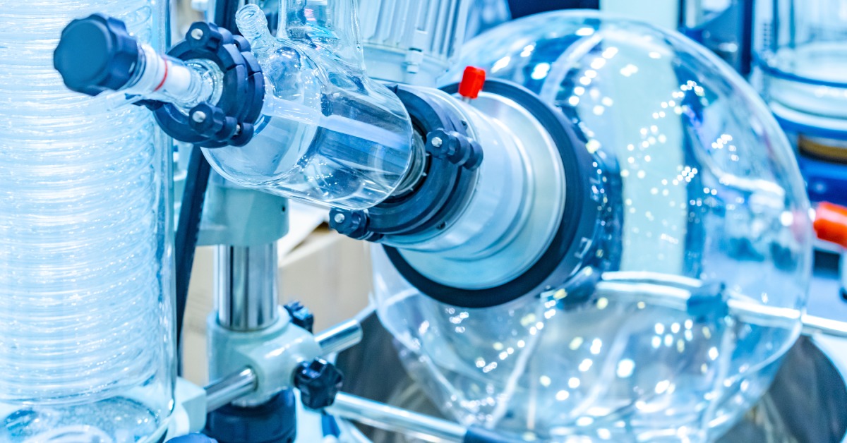 An evaporative flask on a rotary evaporator in a laboratory. The flask connects to various mechanical parts.